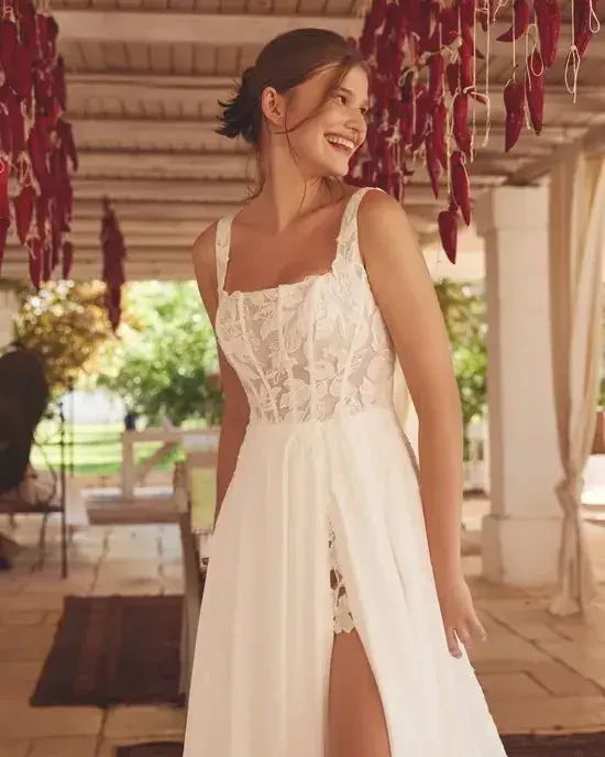 model is wearing a sleeveless a-line chiffon wedding dress
