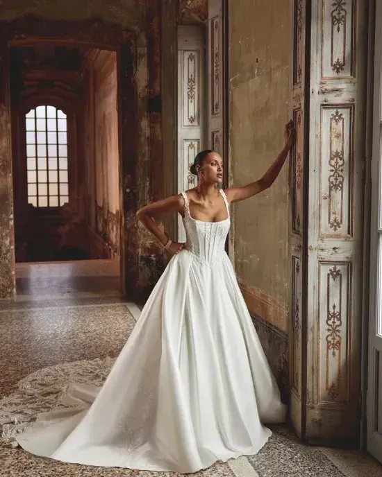 model is wearing a square neckline ball gown wedding dress
