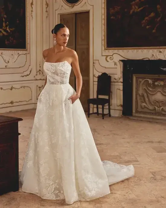 Model is wearing a strapless a-line lace wedding gown