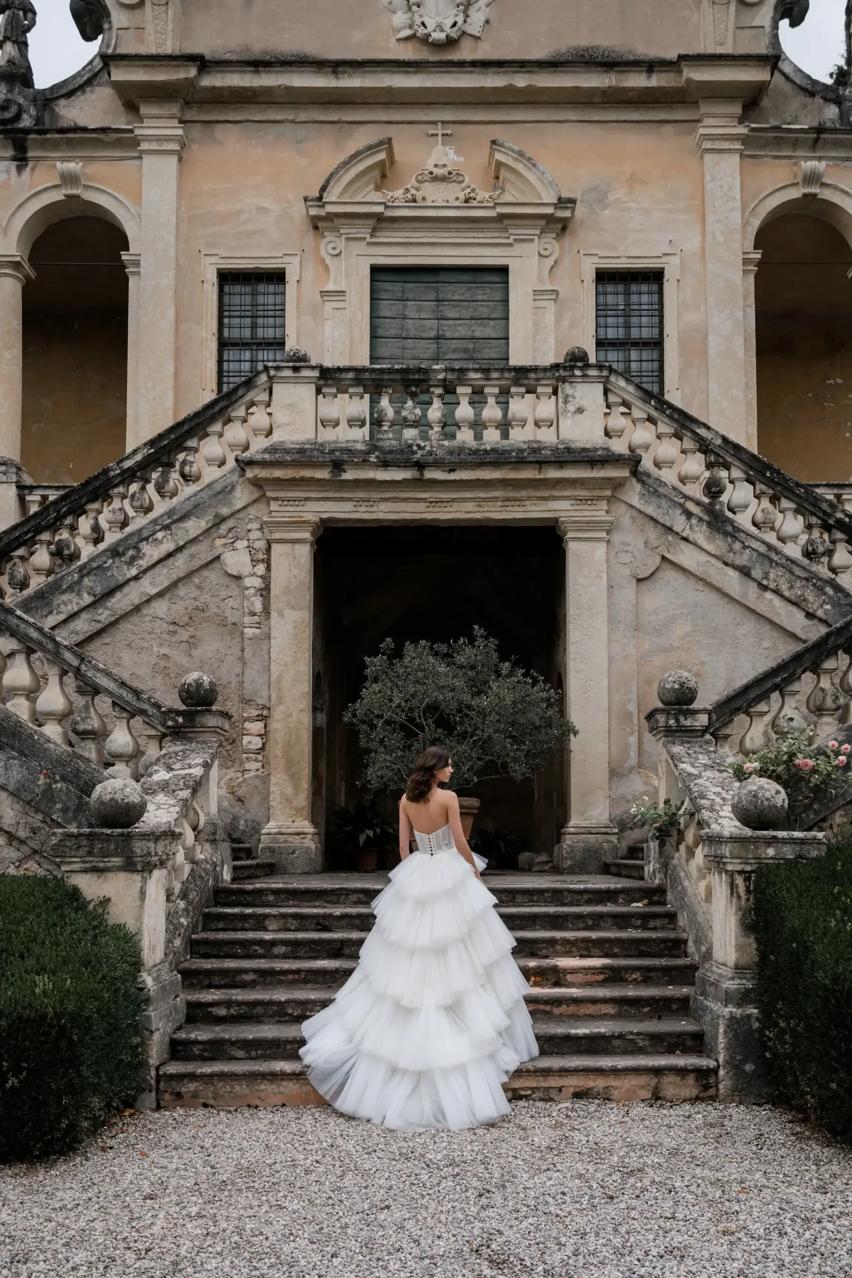 model is wearing a tiered ruffled tulle wedding dress 