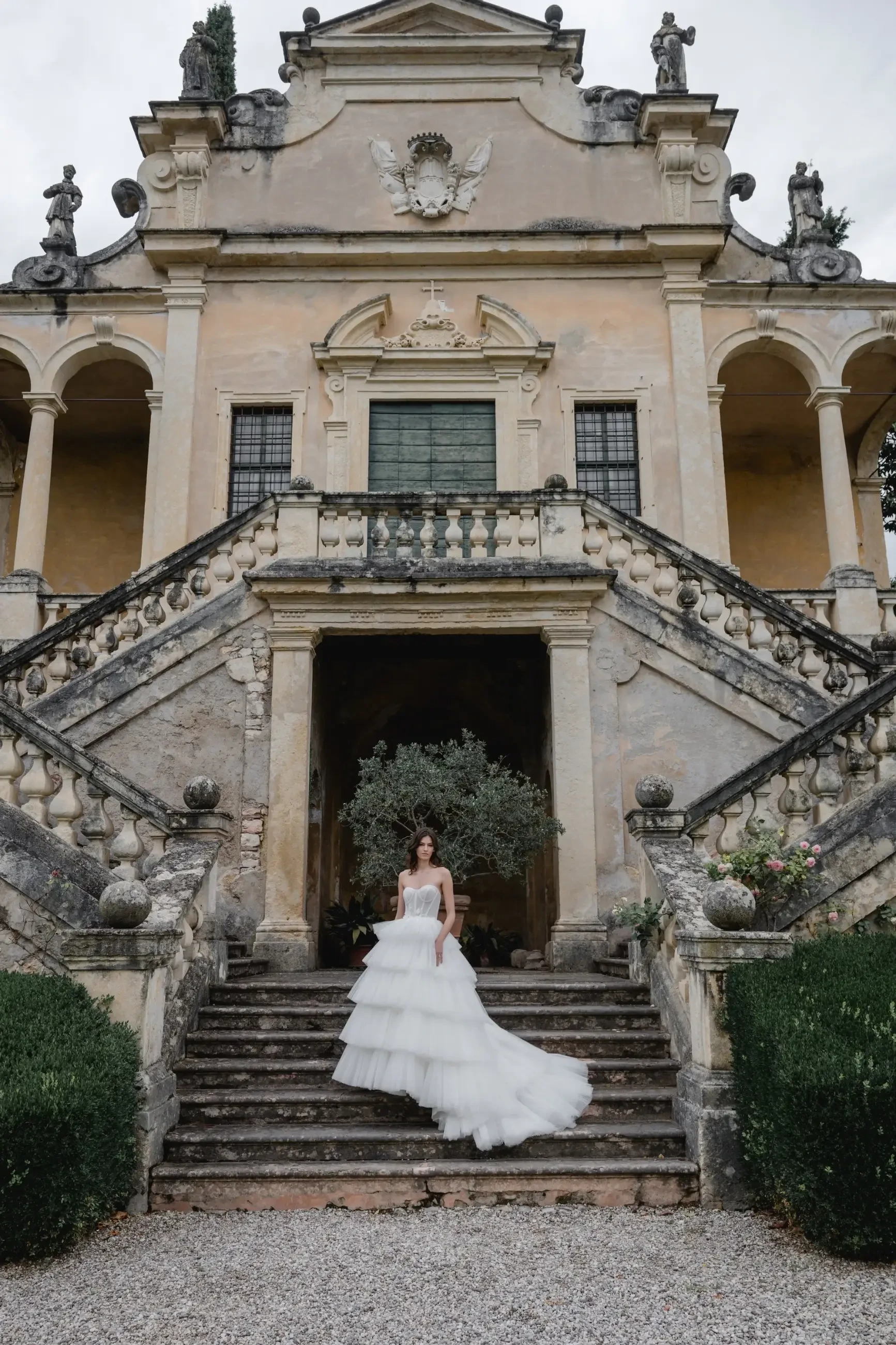 model is wearing a tiered ruffled tulle wedding dress 