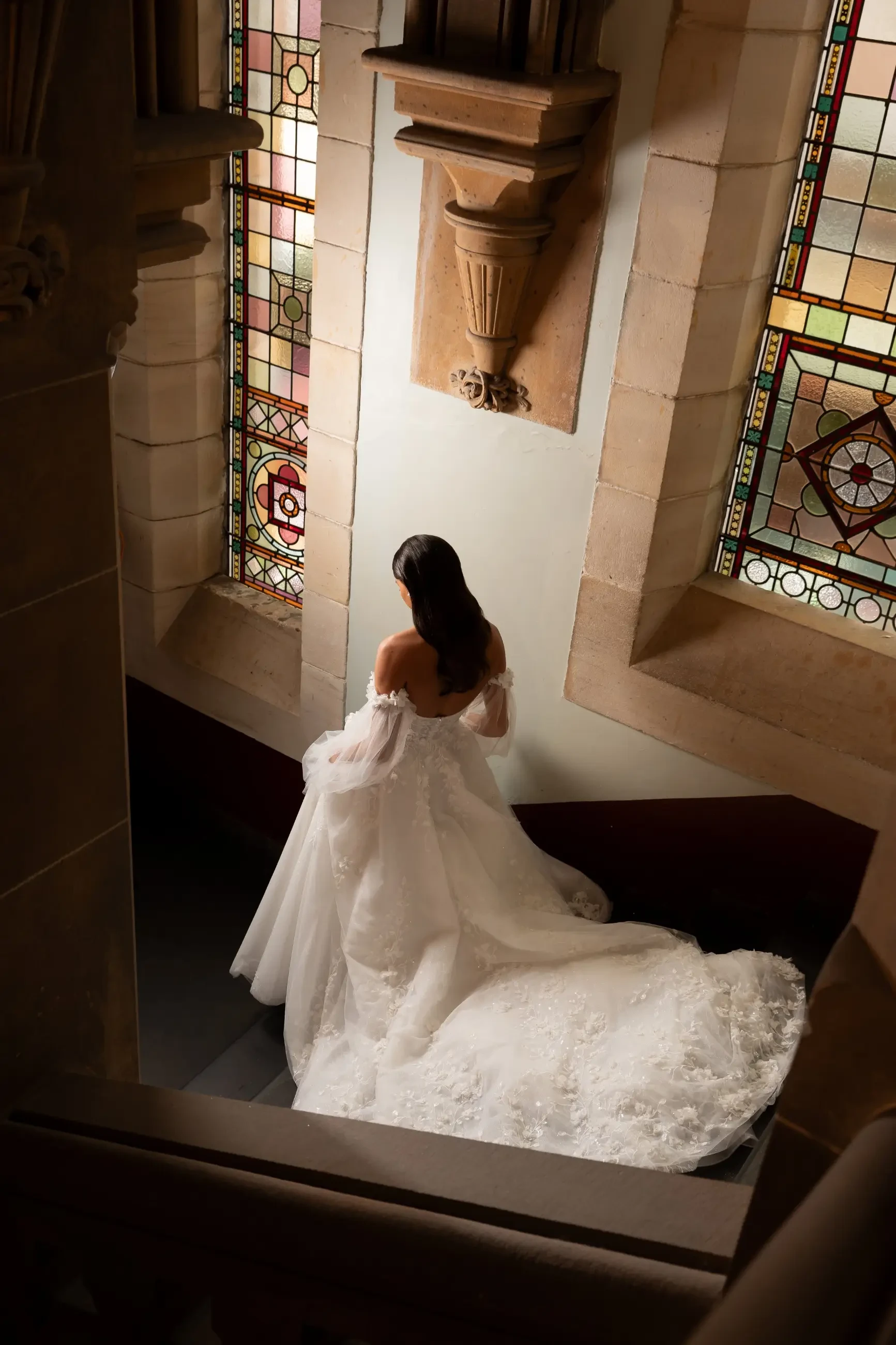 model is wearing an off the shoulder a-line wedding dress from la premiere
