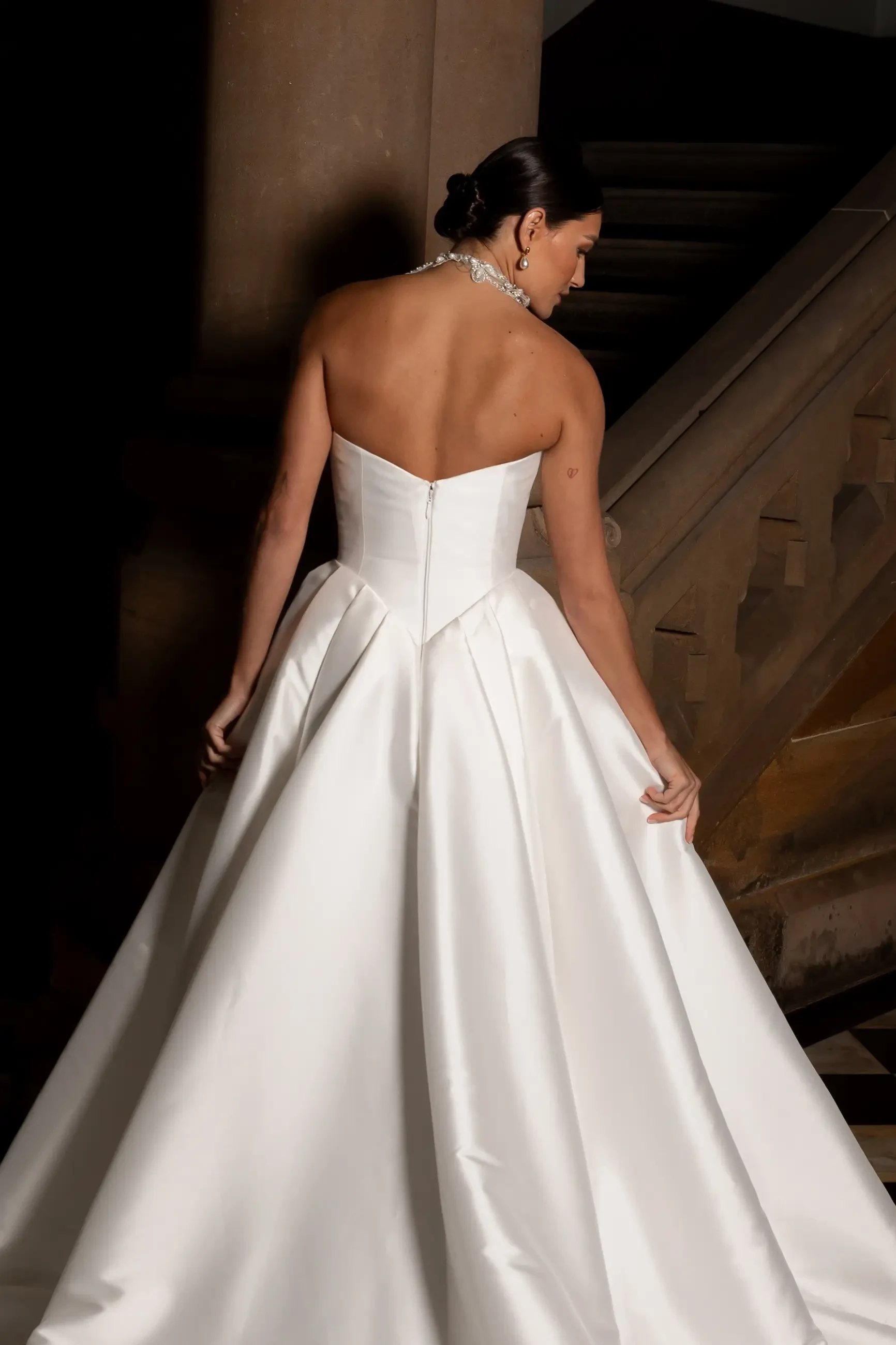 model is wearing a strapless ball gown wedding dress from la premere