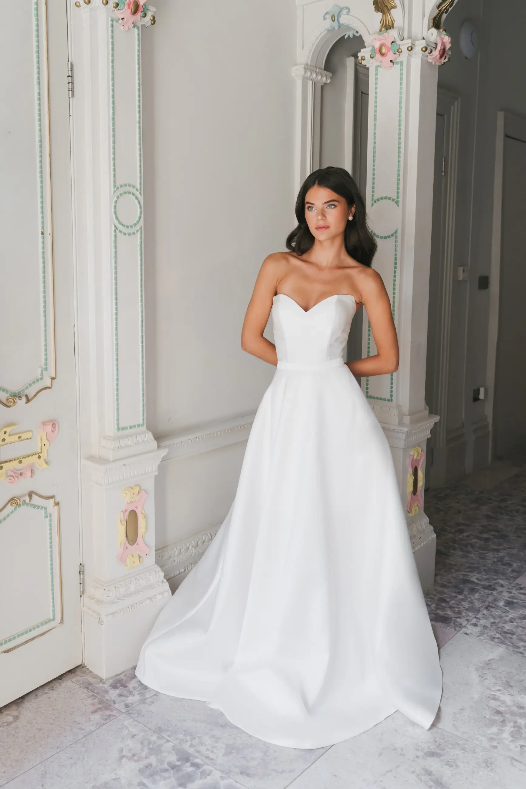 model is wearing a strapless wedding dress by la premiere