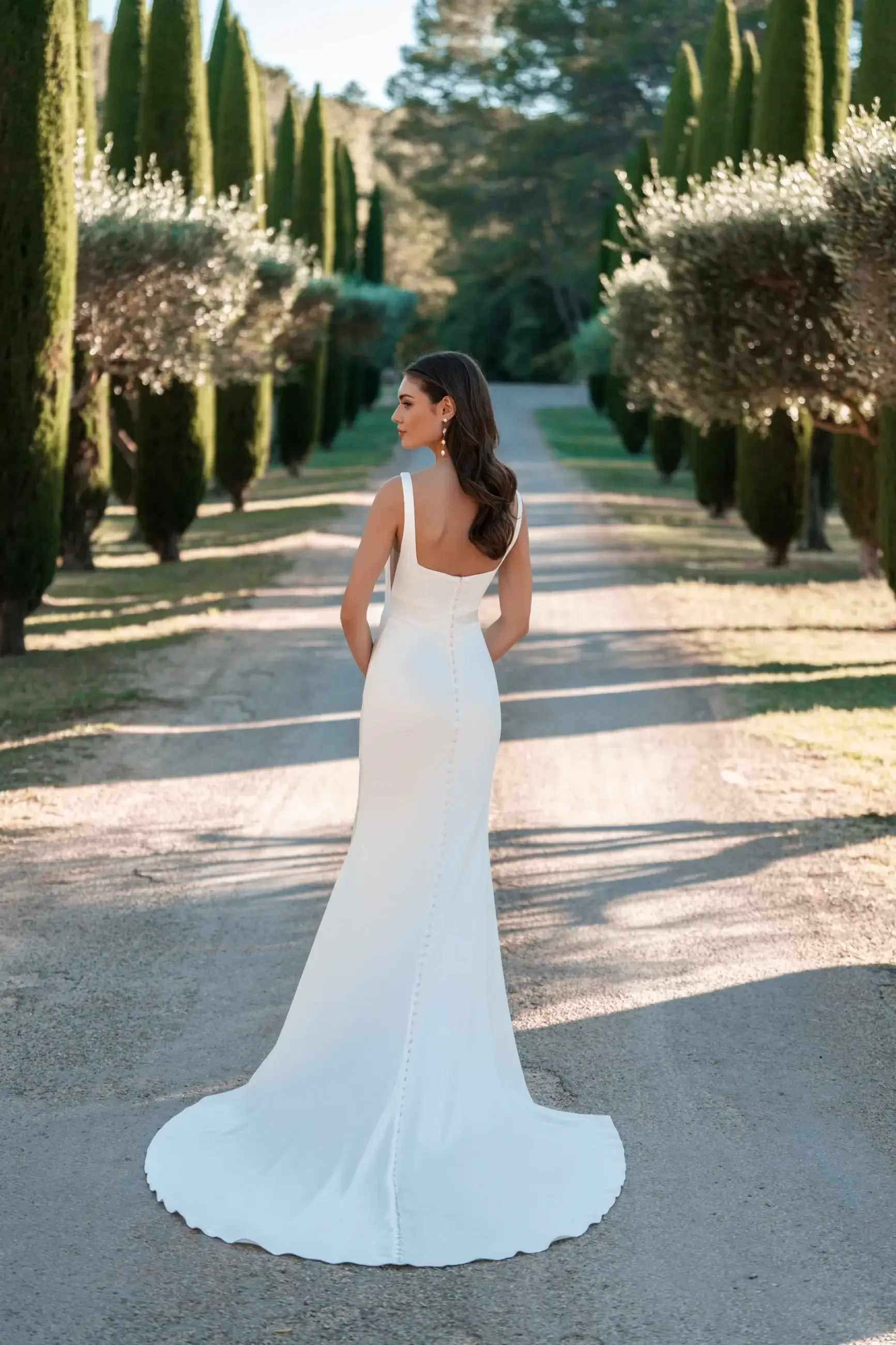 model is wearing a sleeveless sheath bridal gown