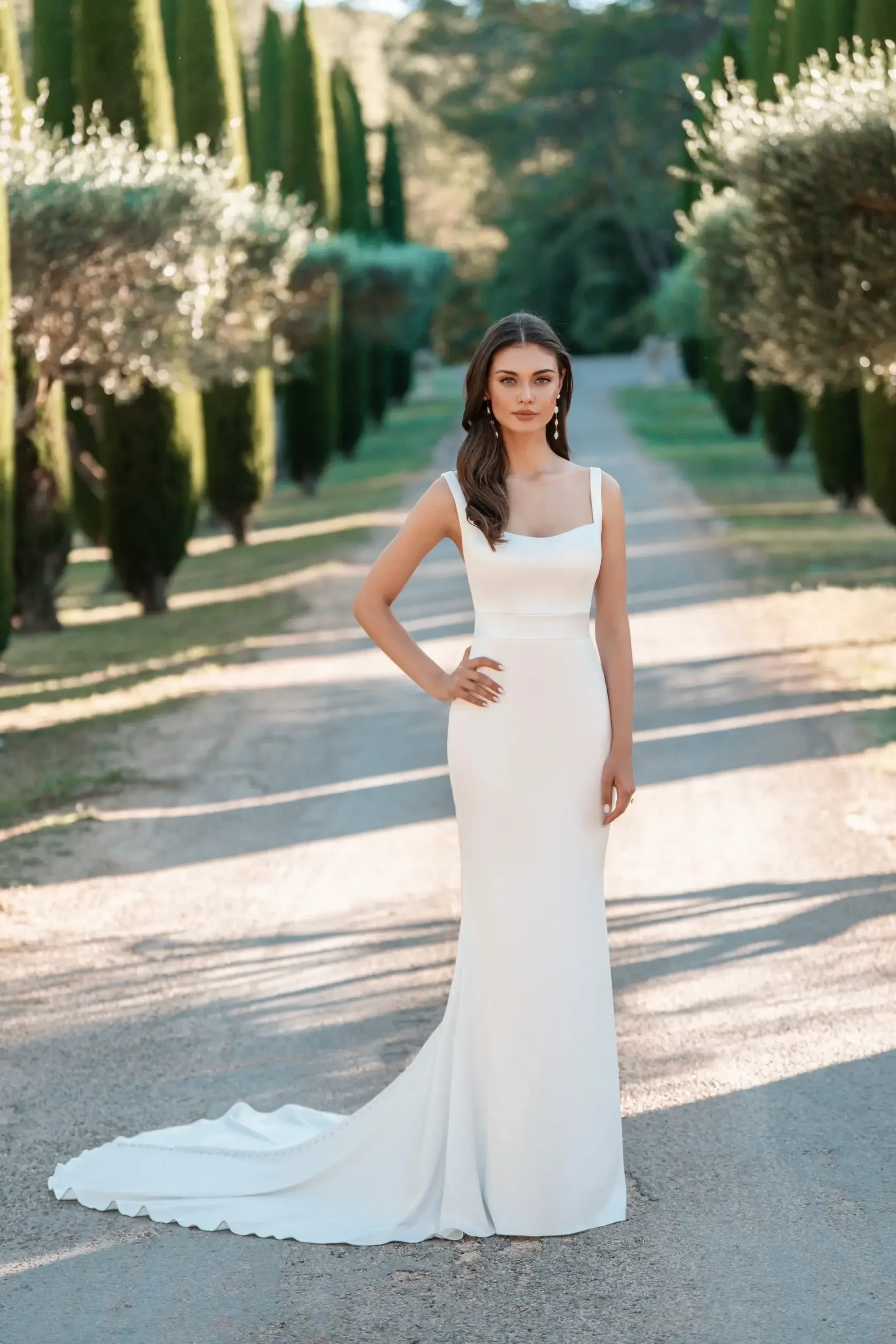model is wearing a sleeveless sheath bridal gown