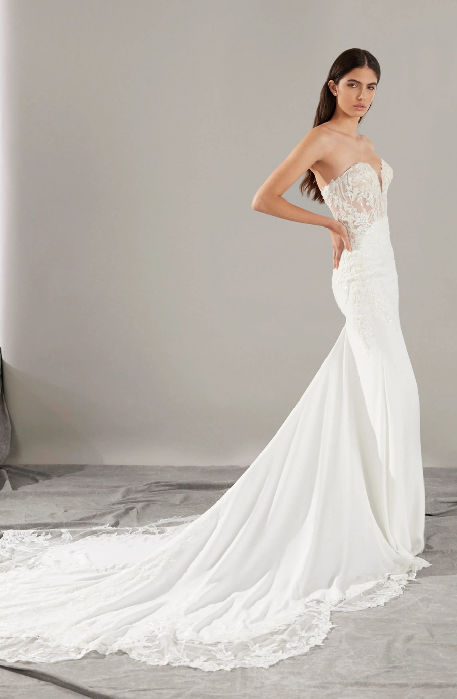 model is wearing a strapless wedding gown with a lace bodice