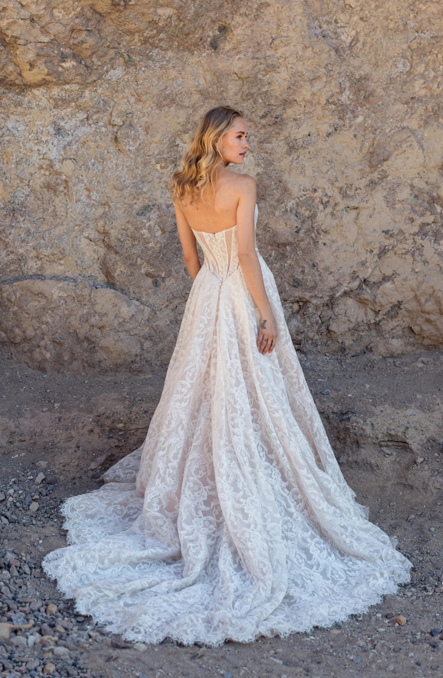 model is wearing a lace strapless ball gown wedding dress