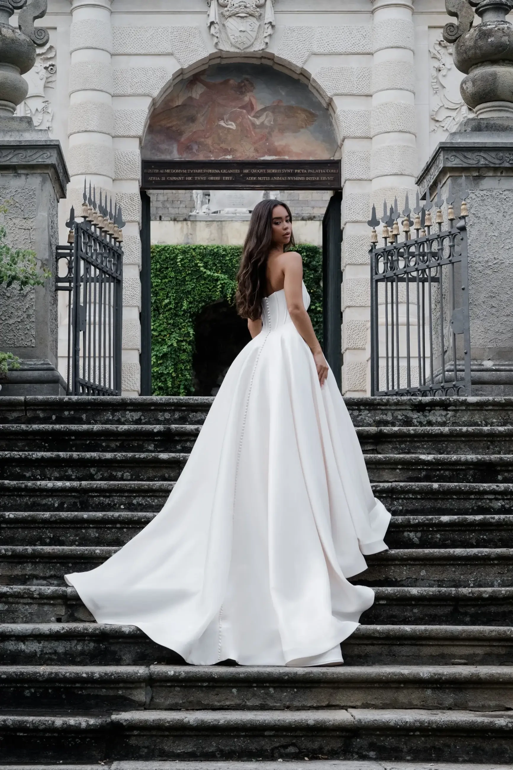 model is wearing a strapless ball gown basque wedding dress
