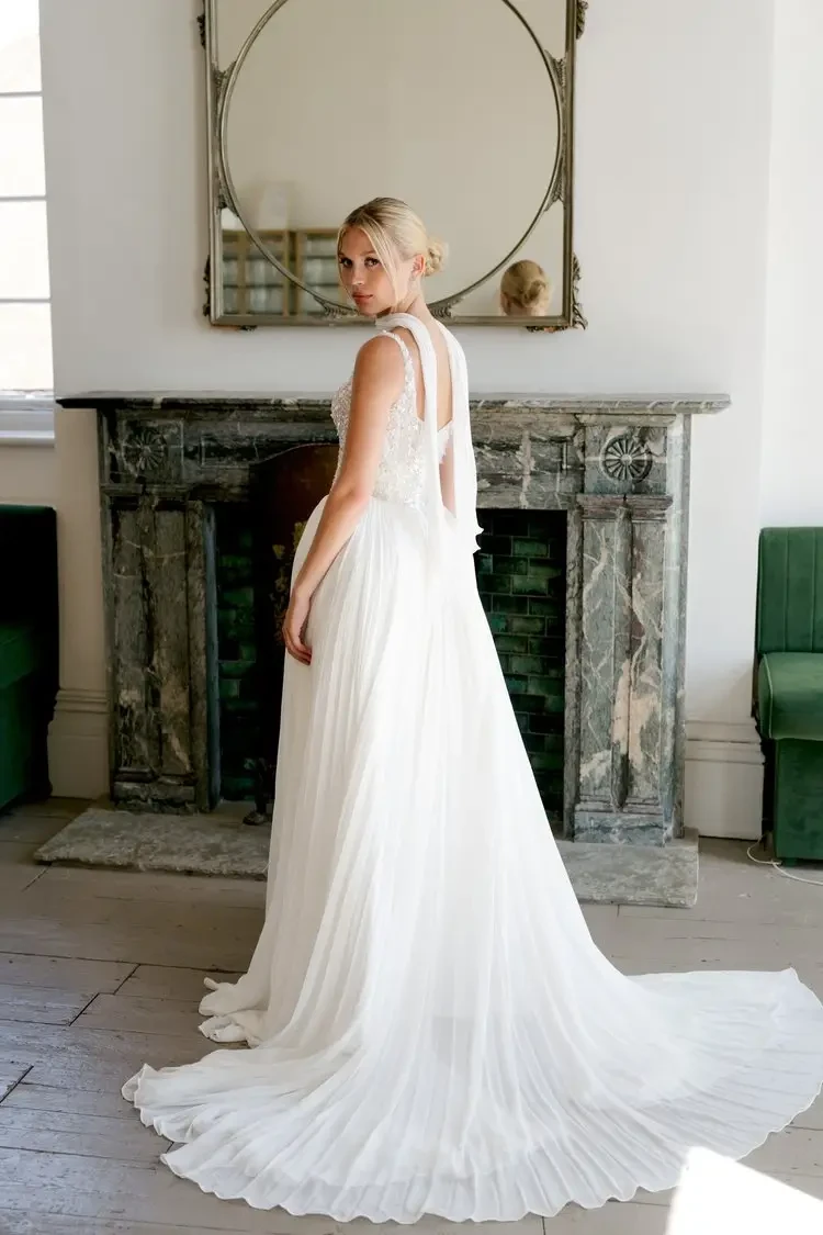 model is wearing a wedding dress with delicate straps and fitted bodice and full skirt