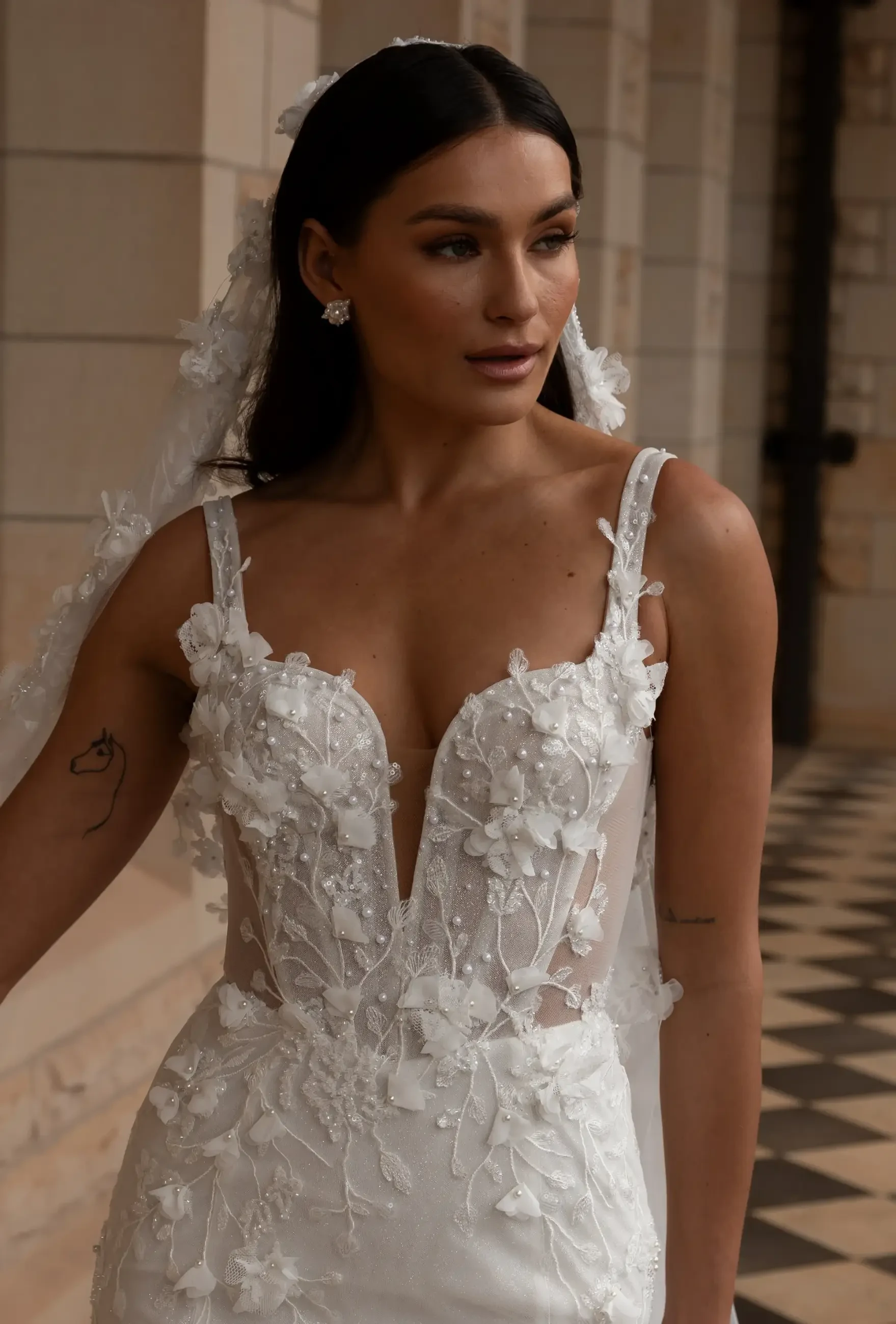 model is wearing a sleeveless fit and flare wedding dress with an open back and v-neckline