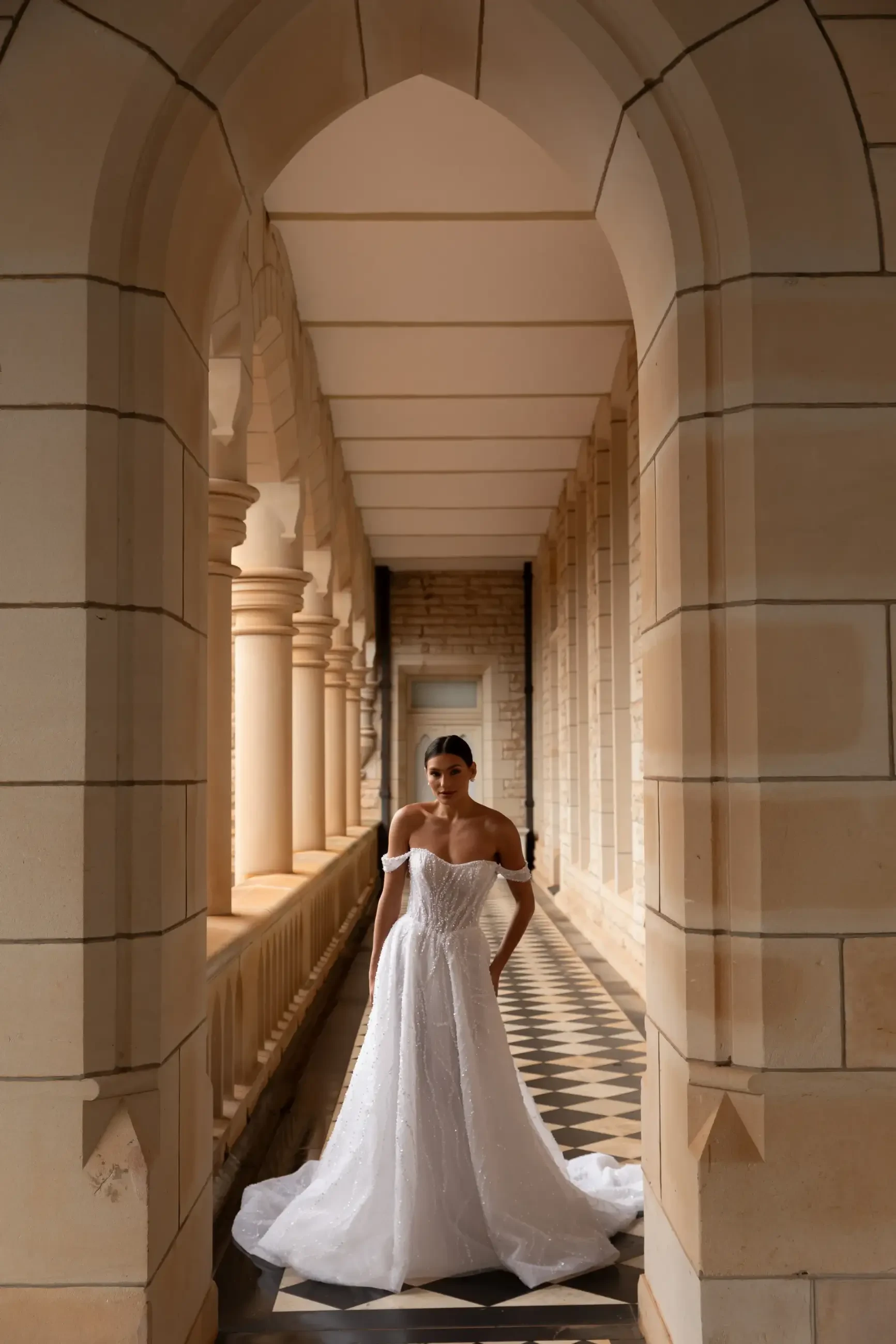 model is wearing an off the shoulder a-line wedding dress from la premiere