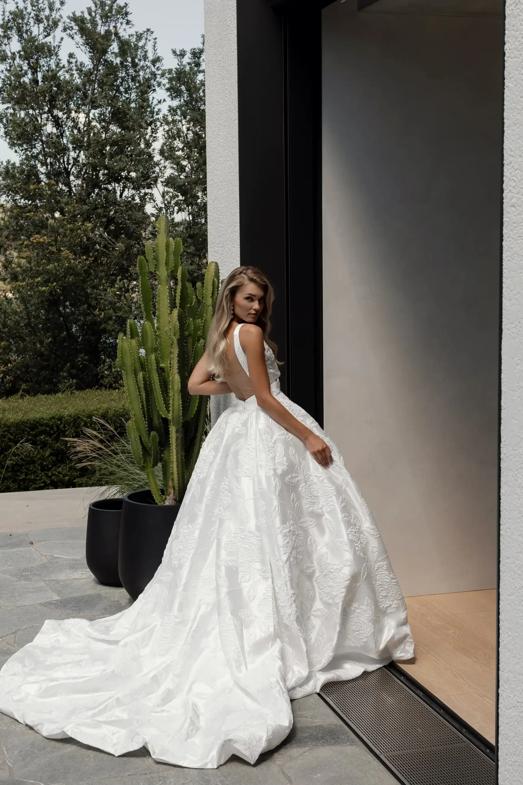model is wearing a sleeveless ball gown wedding dress with a plunging neckline