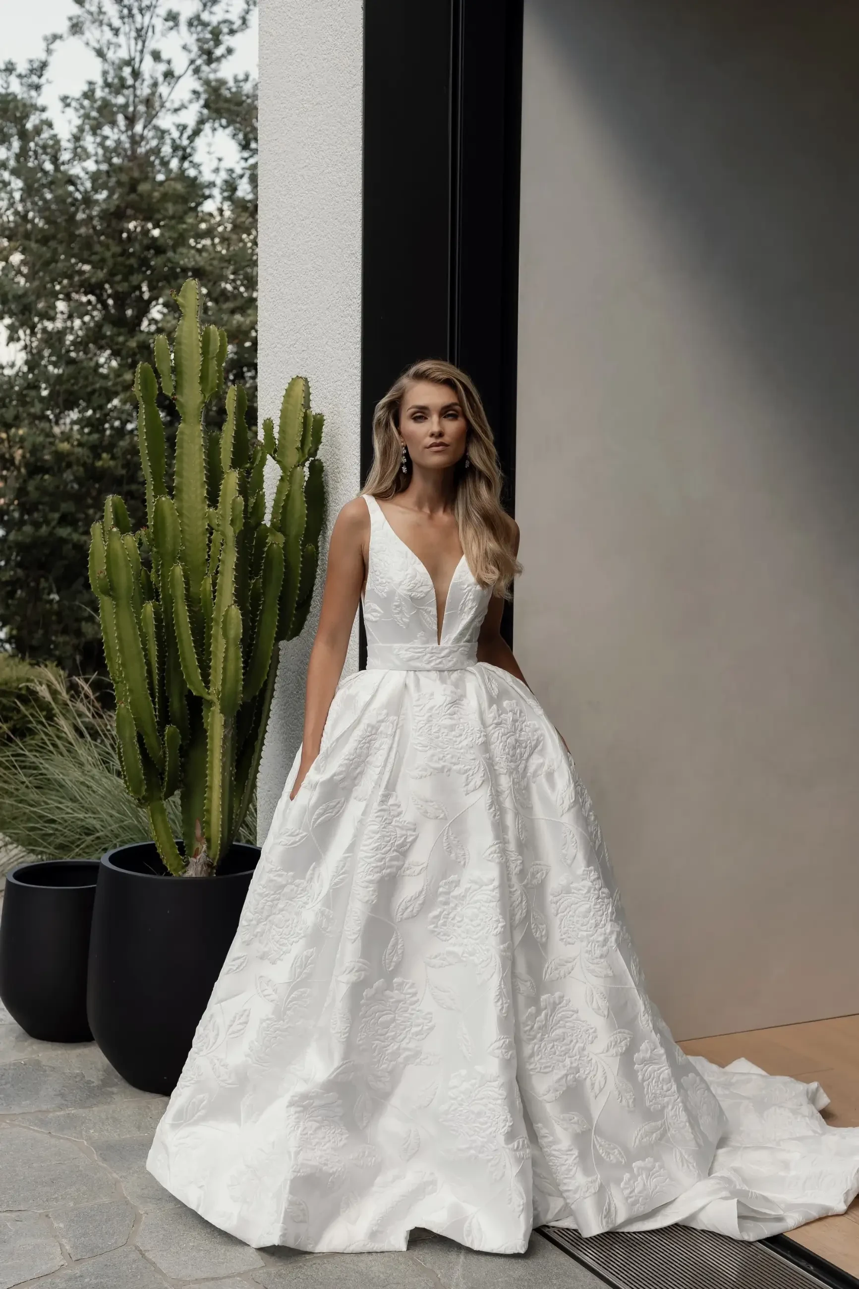 model is wearing a sleeveless ball gown wedding dress with a plunging neckline