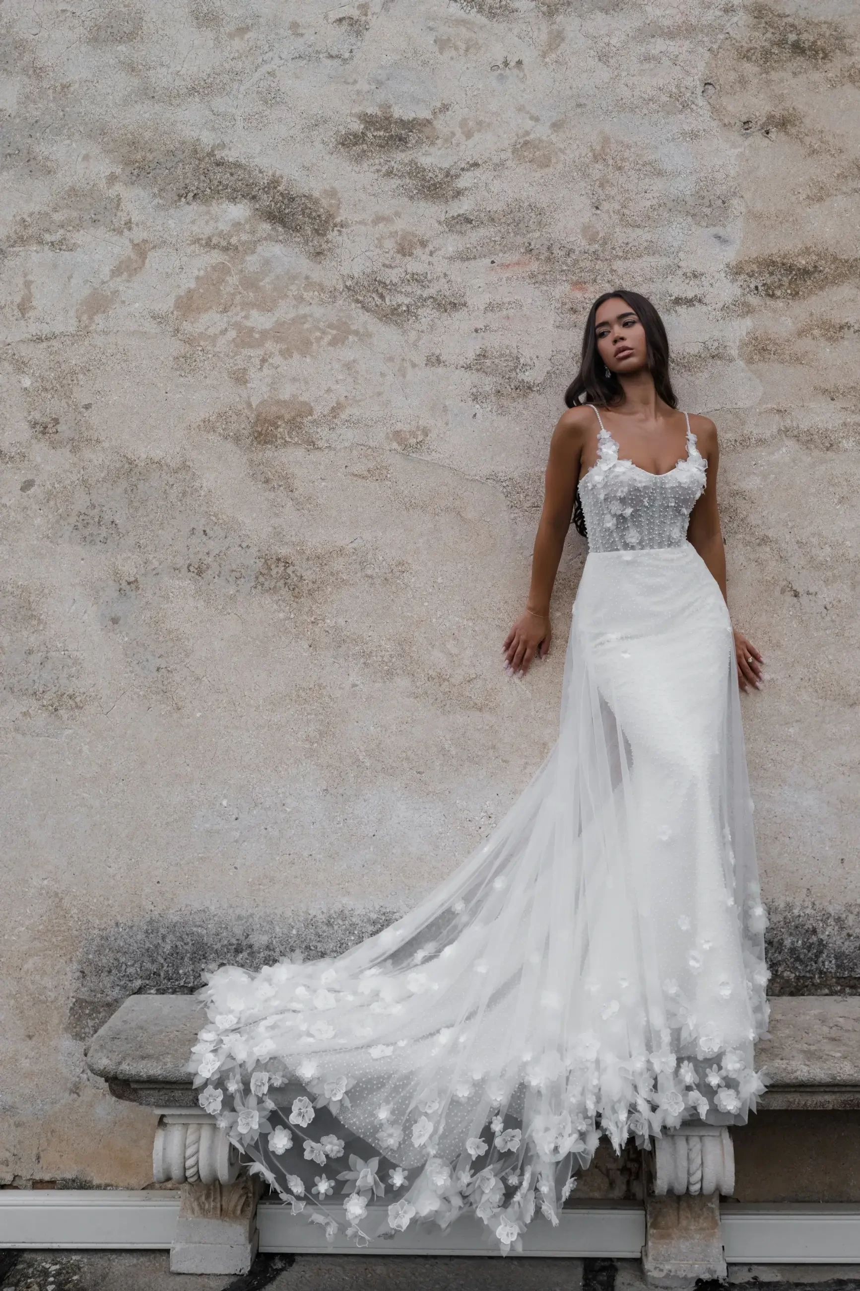 model is wearing a sleeveless fit and flare wedding gown