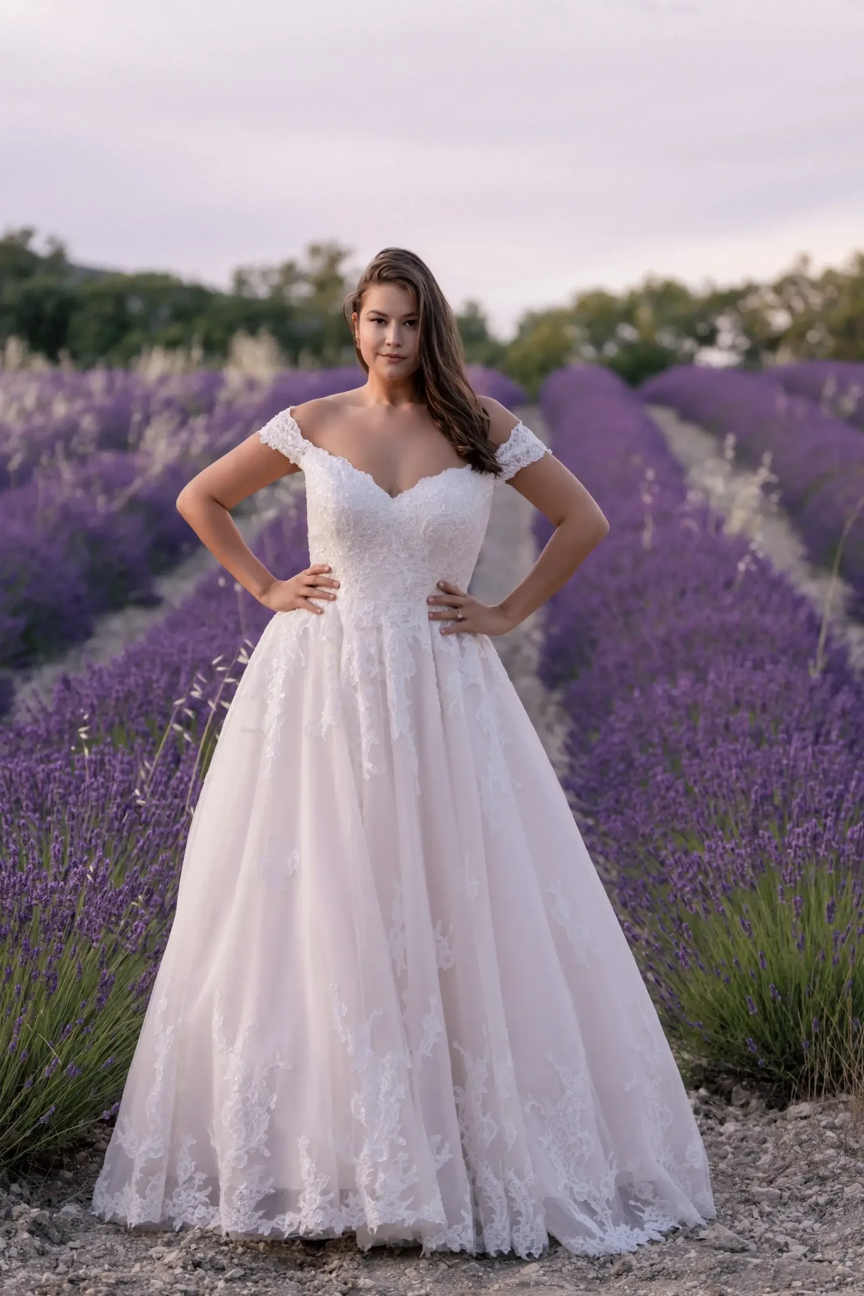 model is wearing a plus size ball gown wedding dress