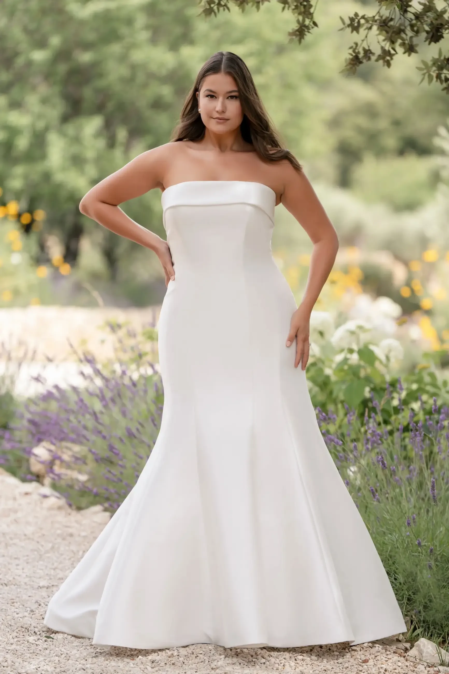 model is wearing a plus size strapless mermaid wedding dress