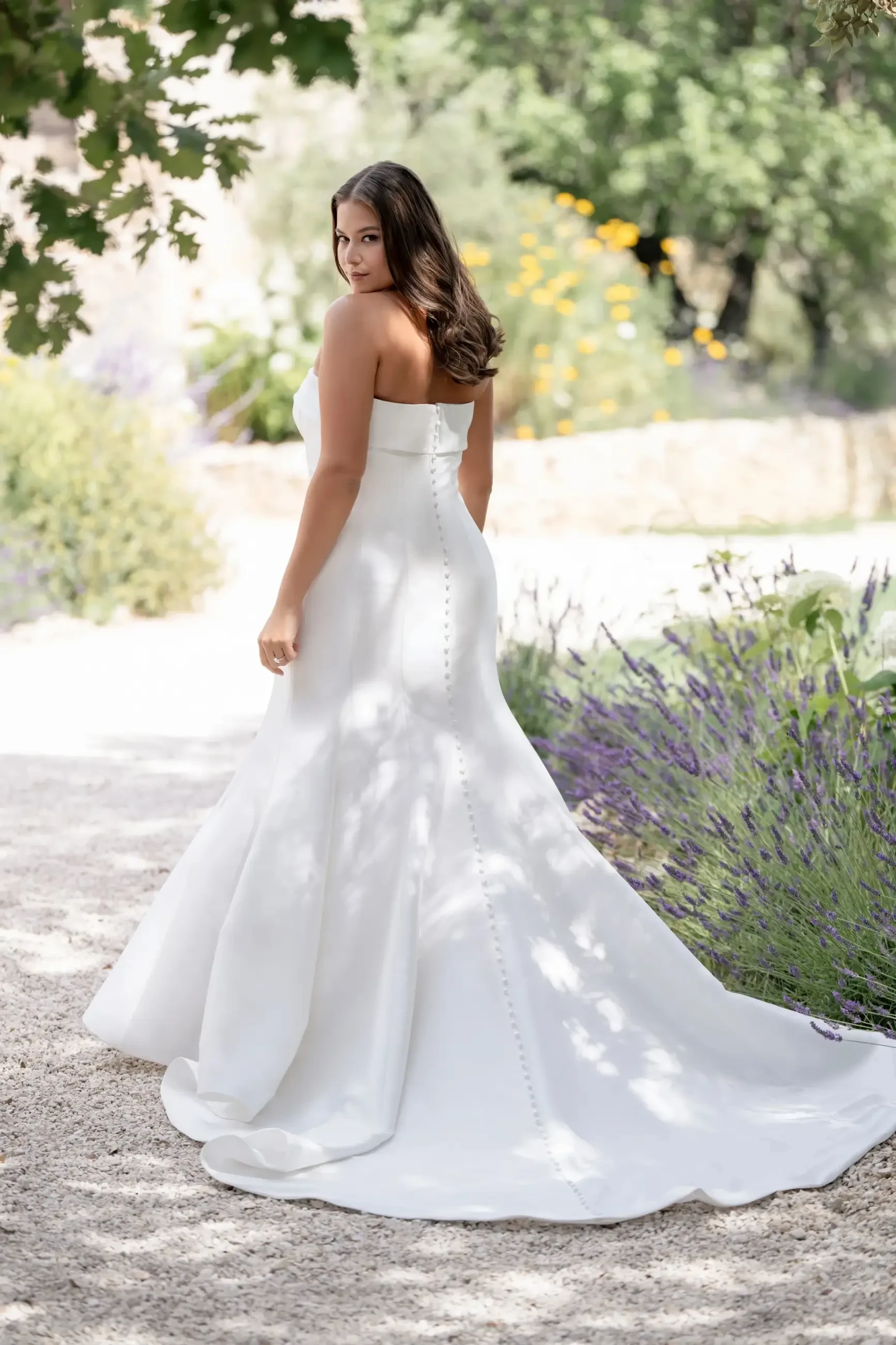 model is wearing a plus size strapless mermaid wedding dress